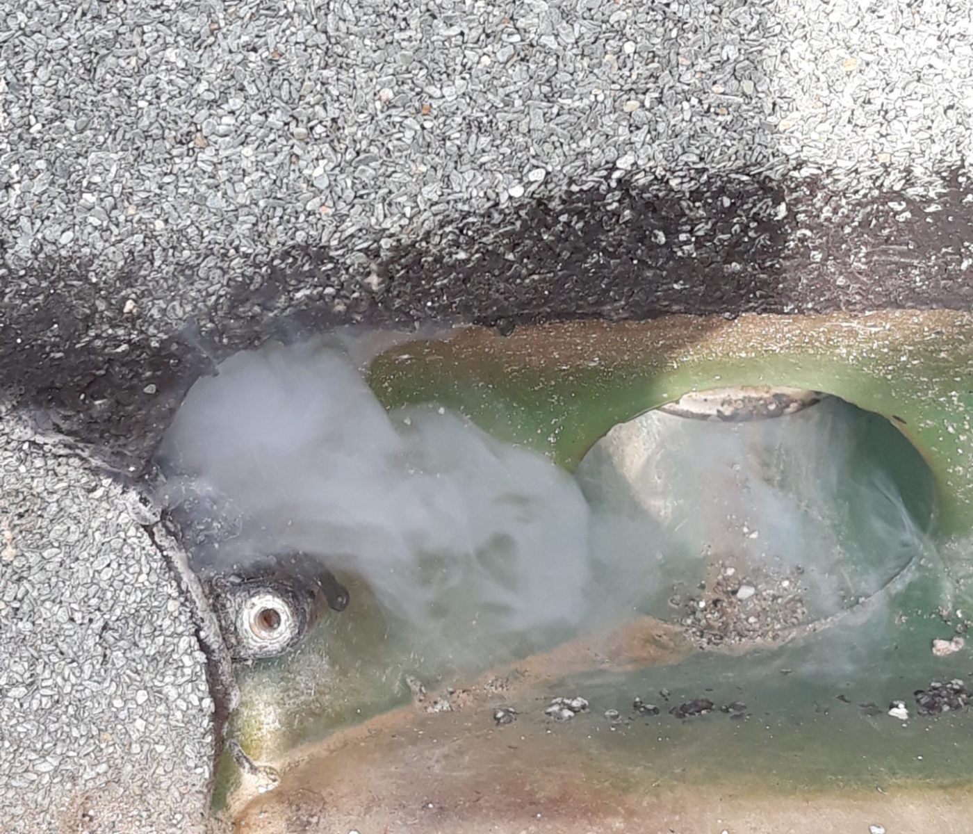 Rauch tritt aus einem Leck im Flachdach aus.